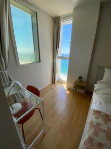 荷茲利亞的住宿－spacious real two bedrooms at the daniel hotel，一间卧室设有一张床、一张玻璃桌和一扇窗户