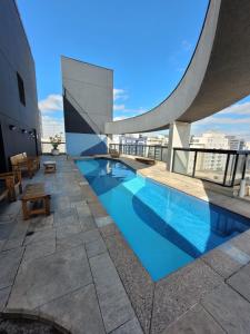 a swimming pool on the roof of a building at Studio Living Slavieiro Moema in Sao Paulo