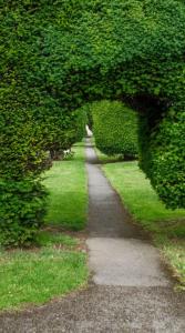 a path through a hedge in a park at Stylish Painswick Getaway in Painswick