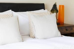 - un lit avec des oreillers blancs et une lampe sur une table dans l'établissement Stylish Painswick Getaway, à Painswick