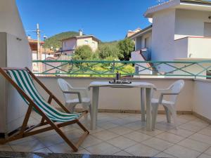 - Balcón con mesa blanca y sillas en Appartamento Vacanze Teulada, en Teulada