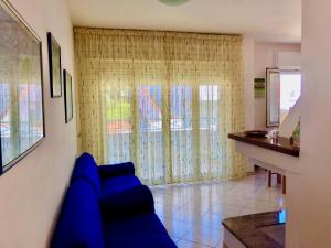 sala de estar con sofá azul frente a una ventana en Appartamento Vacanze Teulada, en Teulada