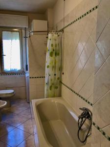 Un baño con bañera y cortina de ducha. en Appartamento Vacanze Teulada, en Teulada