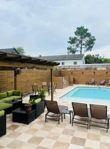 a patio with a swimming pool with chairs and a table at Auld Sweet Olive Bed and Breakfast in New Orleans