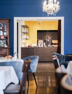 un restaurant avec des murs et des chaises bleus et un comptoir dans l'établissement Hotel SONATA, à Baden-Baden