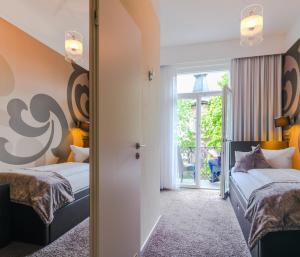 Hotel SONATA في بادن بادن: غرفة نوم بسريرين ونافذة