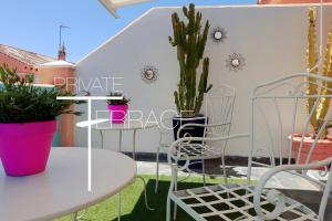 een patio met een tafel, stoelen en planten bij Z&Olé in Torremolinos