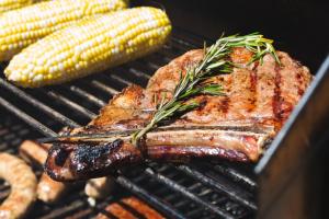 a steak and corn on a grill with corn at Upjohn in Kalamazoo