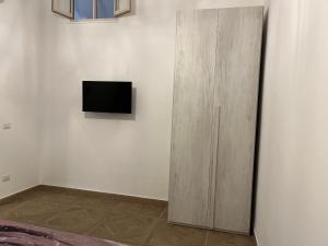 un armadio in legno con una televisione appesa a un muro di Casa Vacanze Velia a Scafati