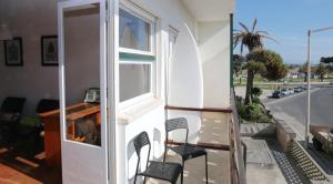 a balcony with chairs and a window and a street at Peniche Housing | Tree The Company in Peniche