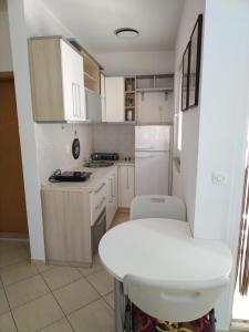 オフリドにある2K Apartmentの小さなキッチン(白いキャビネット、白いテーブル付)