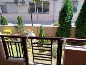 a balcony with a railing with trees and a building at 2K Apartment in Ohrid
