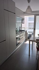 a kitchen with white cabinets and a table in it at Perola da Figueira da Foz in Figueira da Foz