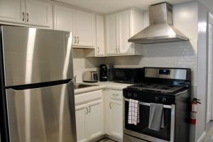 a kitchen with white cabinets and a stainless steel refrigerator at The Clark - Suite 1E - Ocean Grove near Asbury in Ocean Grove