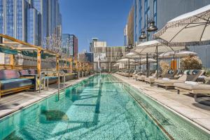 a swimming pool with chairs and umbrellas on a building at Downtown Austin Oasis Luxurious Studio Retreat with amazing Pool and Gym in Austin