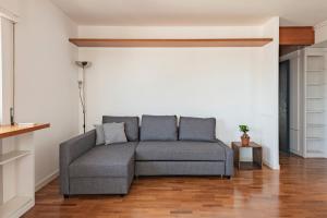 uma sala de estar com um sofá cinzento num quarto em Vatican View Apartment - Zen Real Estate em Roma