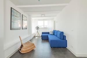 een blauwe bank in een witte woonkamer bij Vatican View Apartment - Zen Real Estate in Rome