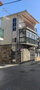 un edificio con balcón en el lateral de una calle en Larga 43/1, en La Adrada