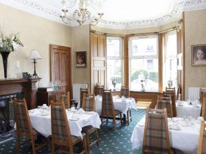 a dining room with tables and chairs and a chandelier at Abbotsford Guest House in Edinburgh