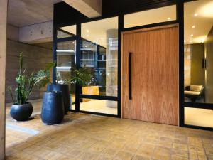 een lobby met een houten deur en twee potplanten bij G&G Apartments - Palermo Cozy Studio in Buenos Aires