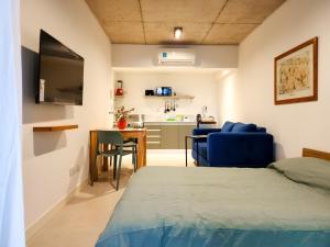 een slaapkamer met een bed, een bureau en een keuken bij G&G Apartments - Palermo Cozy Studio in Buenos Aires