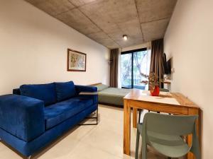 een woonkamer met een blauwe bank en een tafel bij G&G Apartments - Palermo Cozy Studio in Buenos Aires