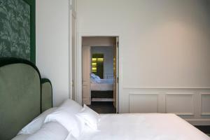 a bedroom with a white bed and a hallway with at Hotel La Gemma in Florence