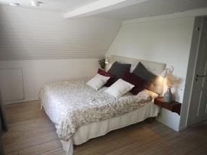 Un dormitorio con una cama con almohadas. en Lindebjerggårds Bed and Breakfast en Melby