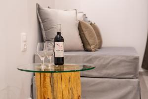 una botella de vino en una mesa junto a un sofá en Airscape Hotel Free Shuttle From Athen's Airport en Loútsa