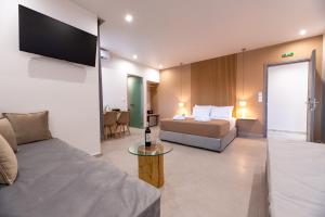 Habitación de hotel con cama y sofá en Airscape Hotel Free Shuttle From Athen's Airport, en Artemida