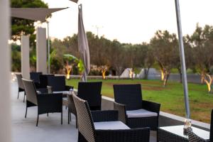 eine Reihe von Tischen und Stühlen mit einem Park im Hintergrund in der Unterkunft Airscape Hotel Free Shuttle From Athen's Airport in Artemida