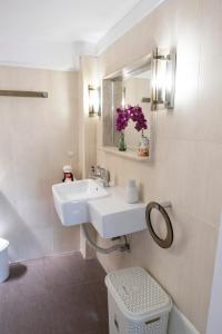 a white bathroom with a sink and a mirror at House 8 in Ermoupoli +27 photos