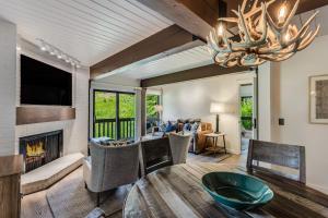 a living room with a fireplace and a table and chairs at Interlude Condominiums 2-Bedroom Unit 204 in Snowmass Village