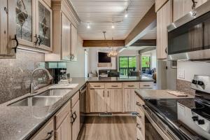 uma cozinha com armários de madeira e um lavatório em Interlude Condominiums 2-Bedroom Unit 204 em Snowmass Village