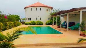 une maison avec une piscine en face d'une maison dans l'établissement La case ronde avec Piscine -Ndayane, à Ndéyane