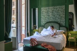 a woman laying in bed using a laptop computer at Hotel La Gemma in Florence