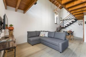 ein Wohnzimmer mit einem grauen Sofa und einer Treppe in der Unterkunft Casas de Xisto in Raiva