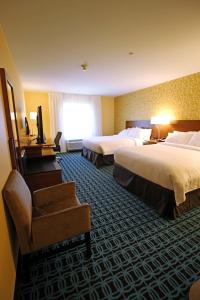 ein Hotelzimmer mit 2 Betten und einem TV in der Unterkunft Fairfield Inn & Suites by Marriott London in London