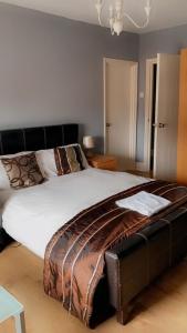 een slaapkamer met een groot wit bed met een zwart hoofdeinde bij 2nd floor shared flat near Bedford train station in Bedford