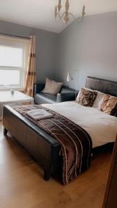 een slaapkamer met een groot bed en een bank bij 2nd floor shared flat near Bedford train station in Bedford