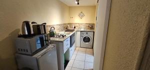 a kitchen with a stove and a washing machine at Walters Lane Economy Apartment 1 - No Loadshedding in Cape Town