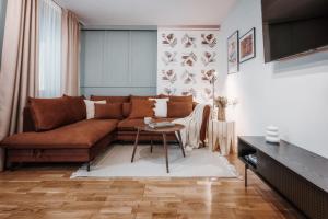 扎科帕內的住宿－Apartament pod Nosalem，客厅配有棕色沙发和桌子