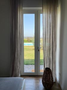 a bedroom with a sliding glass door with a view at THE RANCH Apartment 2 Capalbio in Pescia Romana +30 photos