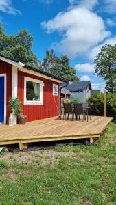 a wooden deck with chairs and a house at Cottage for visiting sea, city, forest in Holm
