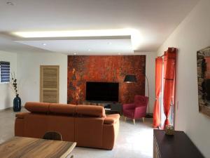 ein Wohnzimmer mit einem Sofa und einem TV in der Unterkunft Superbe villa neuve à 5 mn du centre in Saint-Rémy-de-Provence