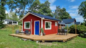 una casita roja pequeña con terraza de madera en Cottage for visiting sea, city, forest, en Holm