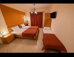 a hotel room with two beds and a tv at Studio Konstantinos in Parga