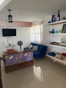 un soggiorno con divano blu e TV di Casa Ibiza Celestun a Celestún
