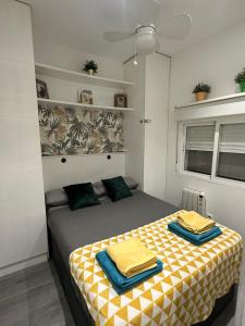 Apartamento 1 hab en La Latina - Madrid Centro في مدريد: غرفة نوم بسرير ذو أغطية صفراء و زرقاء