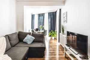 a living room with a couch and a flat screen tv at Komfortowe apartamenty w centrum Wrocławia in Wrocław